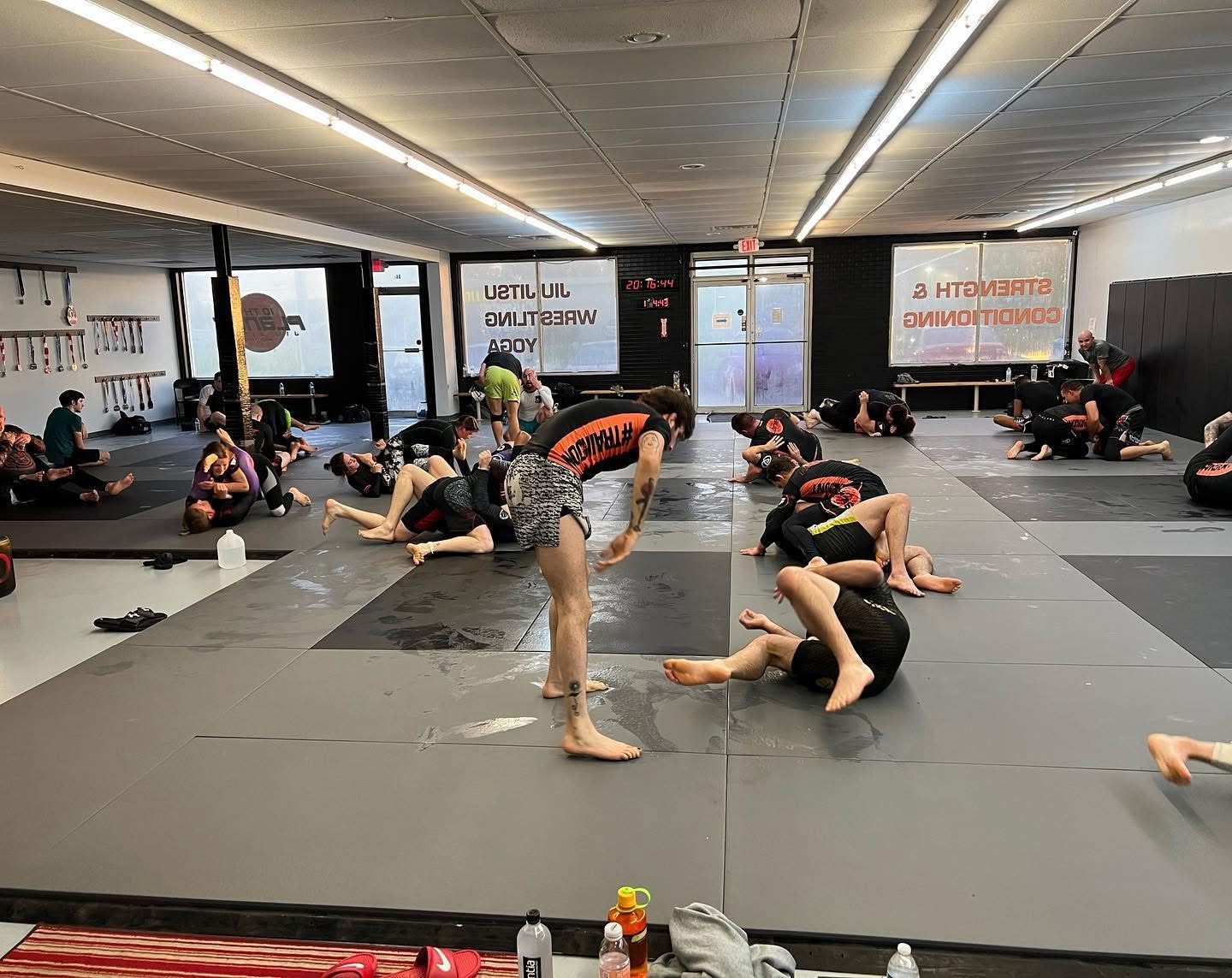 A full adults class rolling on the mats at 10th Planet